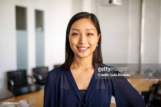 portrait of businesswoman in conference room - solo una donna giovane foto e immagini stock