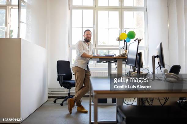 businessman standing at ergonomic desk in office - draft combine portraits stock-fotos und bilder