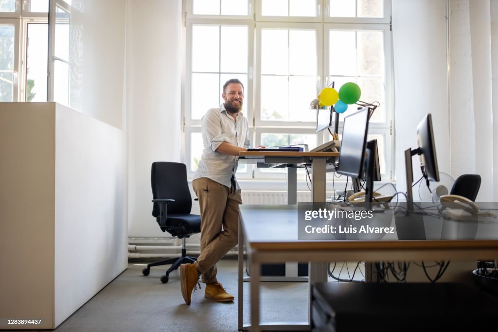 Businessman standing at ergonomic desk in office