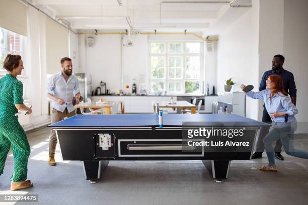 office colleagues playing table tennis during break - friends table tennis stock pictures, royalty-free photos & images