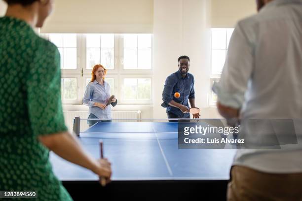 business team enjoying playing table tennis in work break - office ping pong stock pictures, royalty-free photos & images