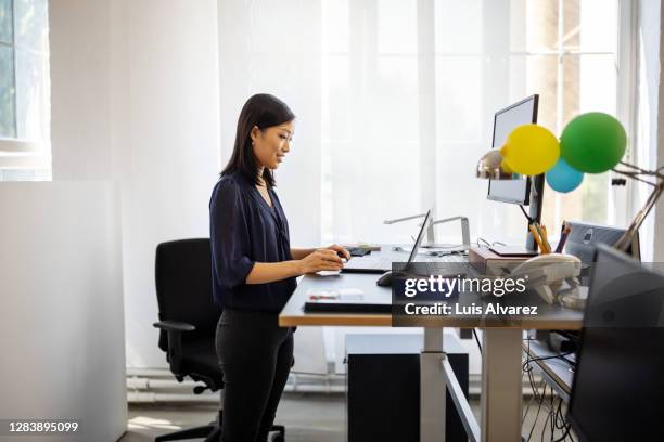 woman having video call on her laptop - ergonomie stock-fotos und bilder