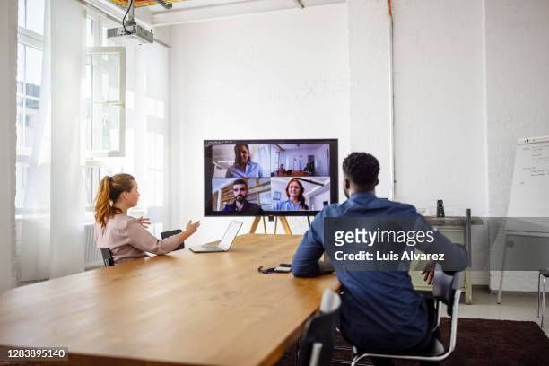 businesspeople having a video conference in office - telecommuting stock pictures, royalty-free photos & images