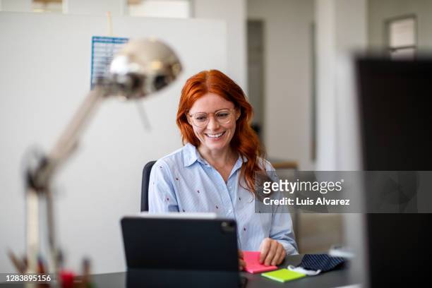businesswoman having a video call at office - woman business desk front laptop office fotografías e imágenes de stock