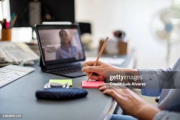 woman making notes during video call - business strategy covid stock pictures, royalty-free photos & images