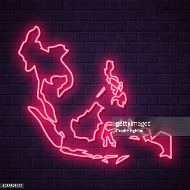 southeast asia map - glowing neon sign on brick wall background - hoarding wall stock illustrations