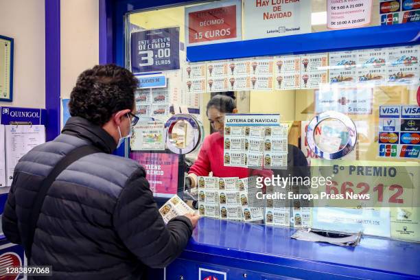 Person at a counter at La Pajarita lottery administration where tickets are sold for the Special Drawing of the Christmas Lottery 2020, on November...