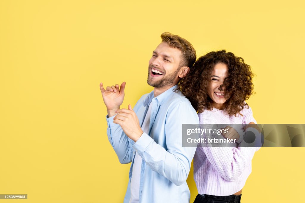 Mann und afrikanische amerikanische Frau stehend auf gelbem Hintergrund