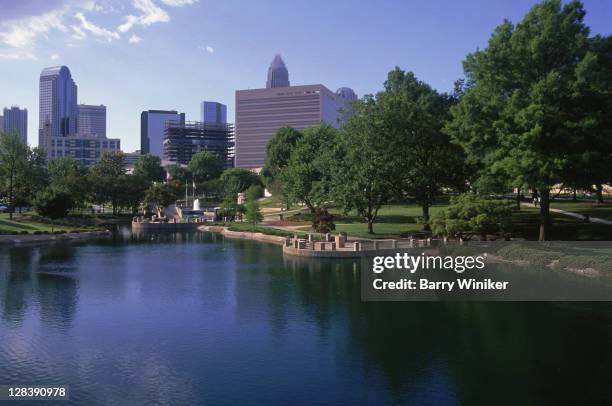 pond and view of downtown buildings, marshall park, charlotte, north carolina, - charlotte north carolina stock pictures, royalty-free photos & images