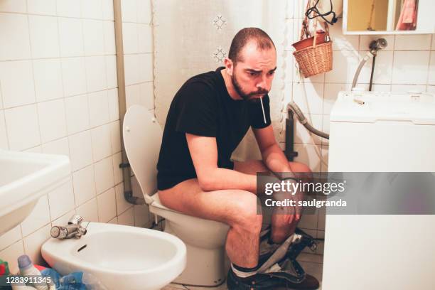 sick man in the toilet - bidet stock-fotos und bilder