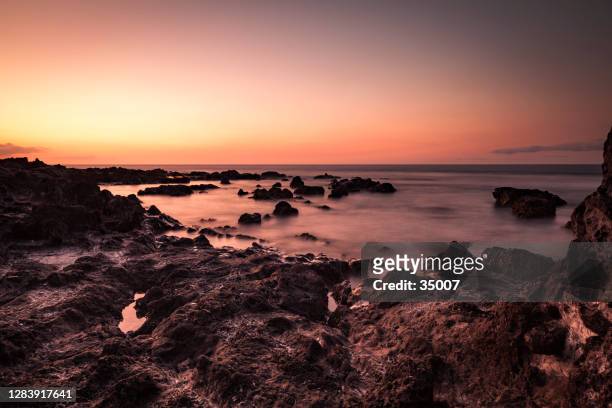 sunset at the rocky coastline of la reunion island - la reunion stock pictures, royalty-free photos & images