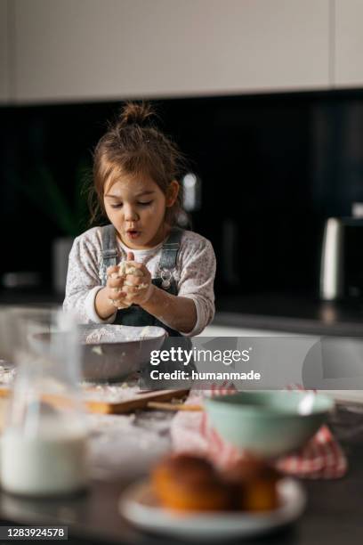 kaukasische mädchen spielen koch in ihrer küche - baby spielt mit essen stock-fotos und bilder