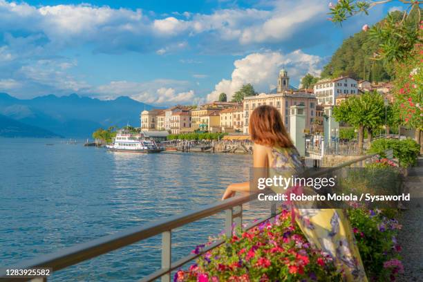 beautiful woman with dress admiring bellagio, lake como, italy - women in see through dresses stock-fotos und bilder
