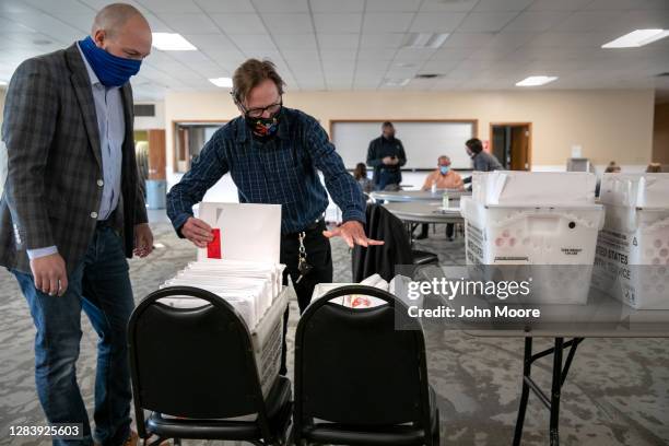 Republican canvasser Anthony Markwort , and Democrat Ted Dawson handle envelopes of poll books to review on November 04, 2020 in Mason, Michigan. As...