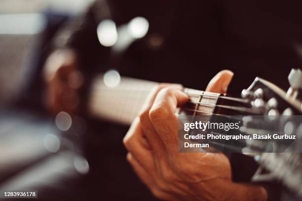 close-up of a man playing guitar - fretboard stock pictures, royalty-free photos & images