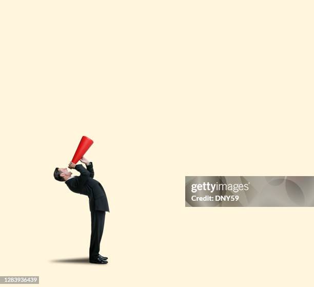 businessman bending over backwards shouting into megaphone - shouting megaphone stock pictures, royalty-free photos & images