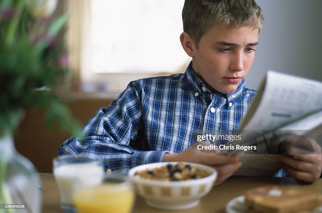 Young boy reading newspaper