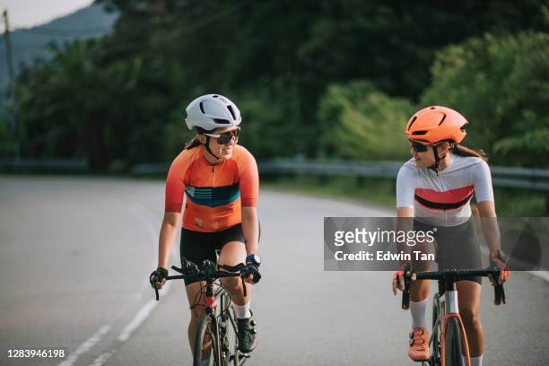 2 asiatiska kinesiska kvinna väg cyklist cykling på landsbygden på morgonen - forward athlete bildbanksfoton och bilder