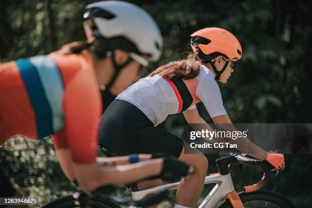 side view competition sport racing 2 asian chinese woman road cyclist cycling in rural area in the morning - cycling team stock pictures, royalty-free photos & images