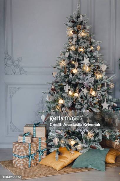 christmas tree with wooden decoration and burning garland. - christmas beauty stock pictures, royalty-free photos & images