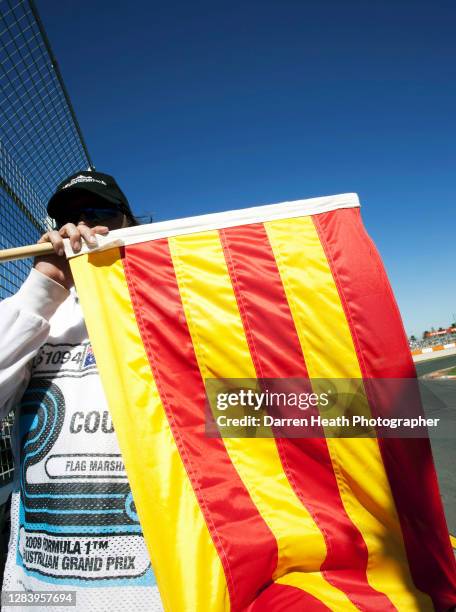 Circuit Safety Marshal shows the yellow and red striped fluid flag during practice for the 2009 Australian Grand Prix at the Melbourne Grand Prix...