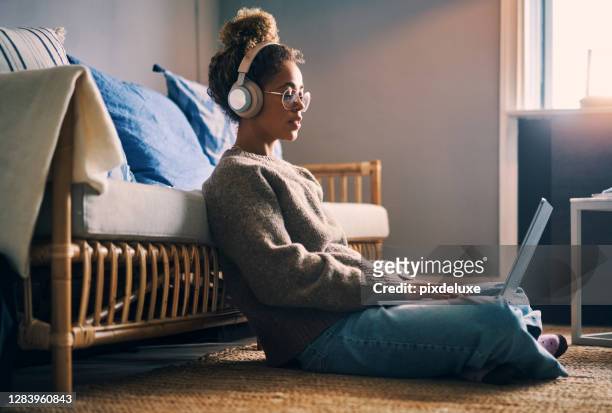 music keeps her productive - young adult on laptop stock pictures, royalty-free photos & images
