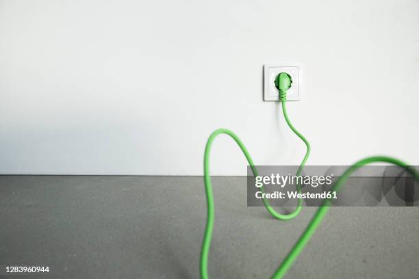 close-up plug with cable in outlet at home under construction - electric plug stock pictures, royalty-free photos & images