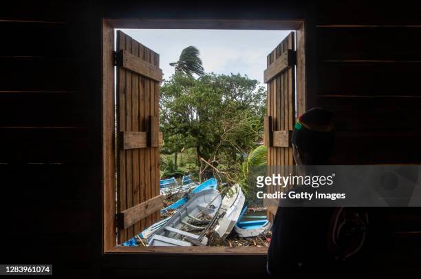 Man loos through the window at wrecked boats on the day after the devastating passage of the hurricane Eta on November 04, 2020 in Barrio El Muelle,...