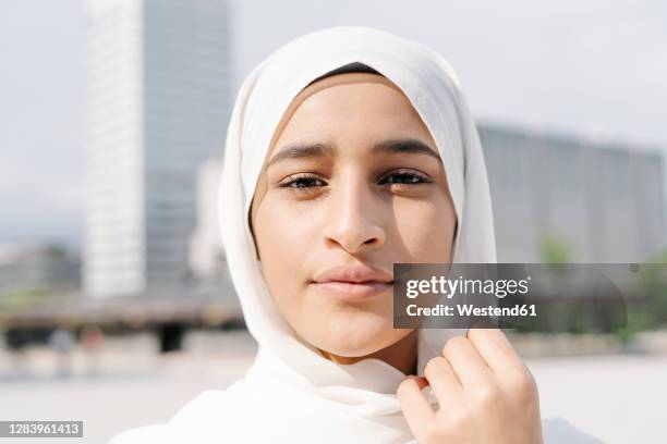 confident teenage girl wearing headscarf in city during sunny day - beautiful arab girl 個照片及圖片檔