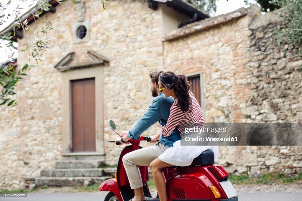 Couple enjoying road trip on Vespa
