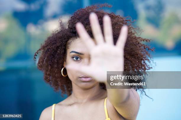 close-up of young woman showing stop sign - basta foto e immagini stock