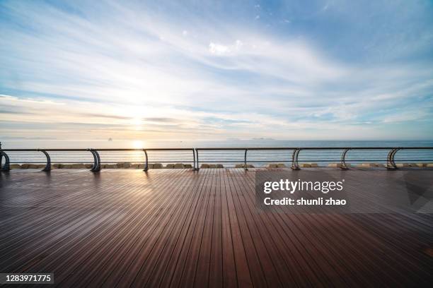 boardwalk by the sea at sunrise - paso entablado fotografías e imágenes de stock