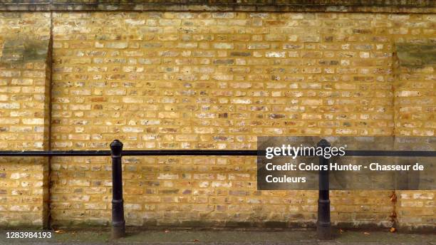 weathered brick wall with black metal grid in london - wall building feature stock pictures, royalty-free photos & images