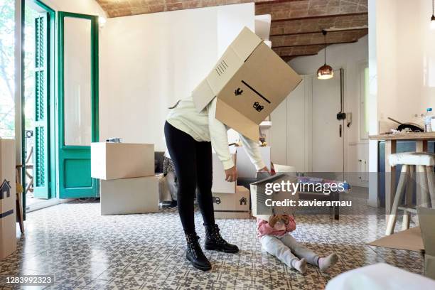 mother and young daughter playing with boxes on moving day - children funny moments stock pictures, royalty-free photos & images