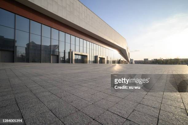 glass building and marble floor on the square - glass building road stockfoto's en -beelden