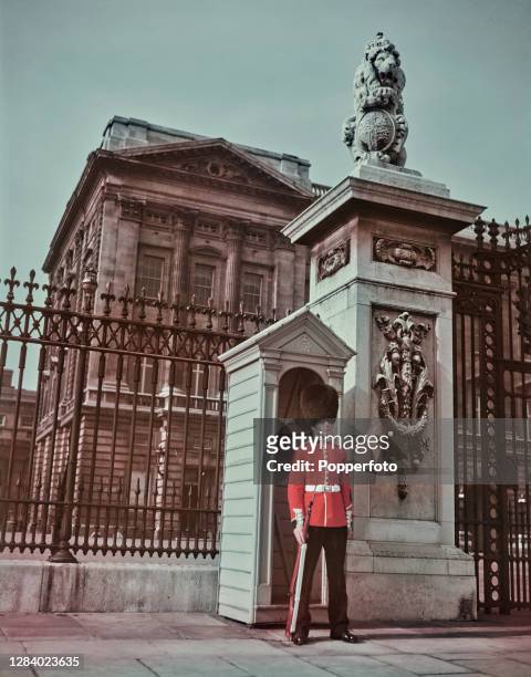 British Army infantry soldier from the Grenadier Guards regiment stands on guard duty outside Buckingham Palace in London in May 1951.