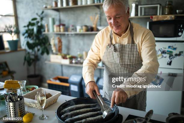 chef preparing fish for lunch at home - polytetrafluoroethylene stock pictures, royalty-free photos & images