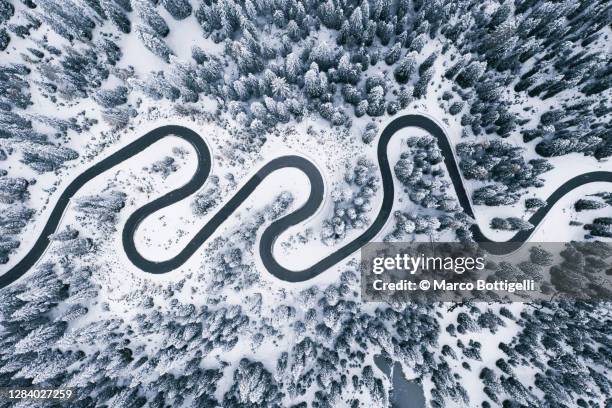 overhead aerial view on winding road in winter landscape - snowy mountain road stock pictures, royalty-free photos & images