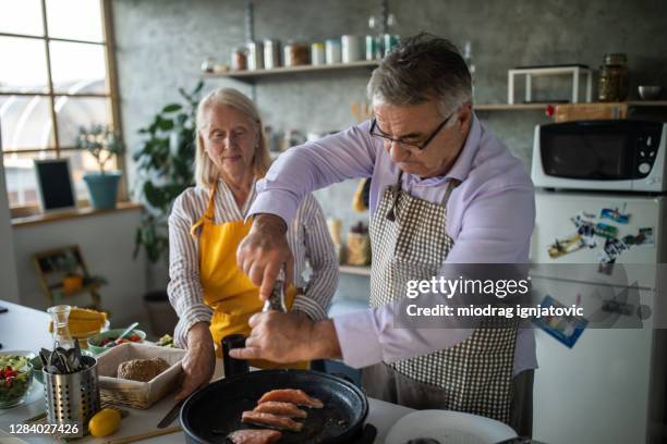 hoger paar dat gezonde maaltijd samen thuis voorbereidt - house warm heating oil stockfoto's en -beelden