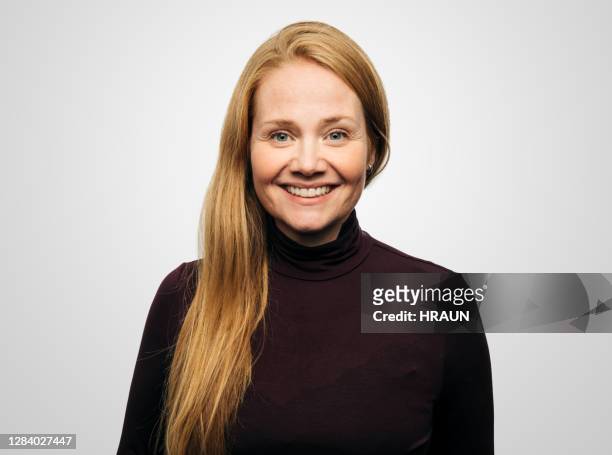 gelukkige roodharige vrouw tegen witte achtergrond - formeel portret stockfoto's en -beelden