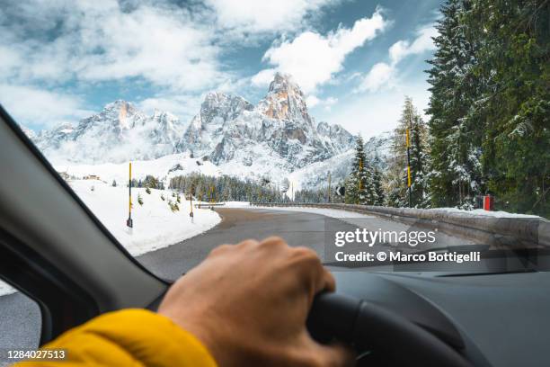 personal perspective of man driving car in the dolomites, italy - winter car window foto e immagini stock