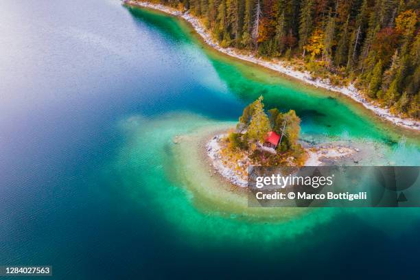 aerial view of small island on emerald green lake, germany - island hut stock pictures, royalty-free photos & images