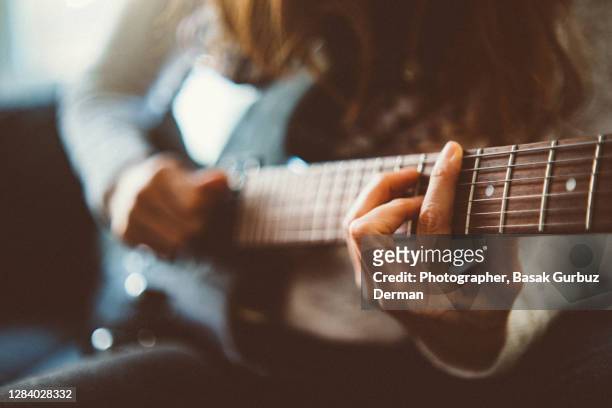 a woman playing a guitar - woman electric guitar stock pictures, royalty-free photos & images