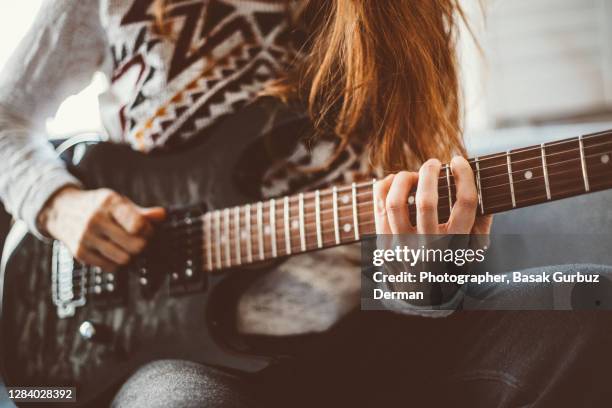 a woman playing a guitar - heavy metal electric guitars stock pictures, royalty-free photos & images
