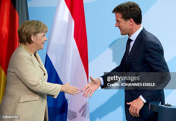 German Chancellor Angela Merkel is to shake hands with Dutch Prime Minister Mark Rutte as they give a press conference on October 7, 2011 at the...