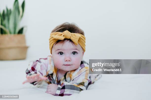 Adorable bebé tumbado boca abajo sobre una colorida colchoneta para niños  con su puño en la boca. Retrato de un bebé alegre jugando en el suelo. Bebés  felices que tienen f Fotografía