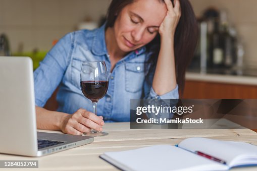 Depressive Frau trinkt Rotwein zu Hause. Depressive Frau trinkt Rotwein zu Hause.