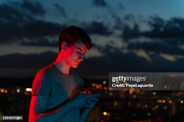 teenager mit smartphone in der dämmerung - spain teen face stock-fotos und bilder