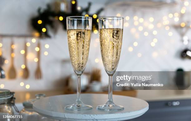 glasses with champagne on the background of christmas decorations. - champagne glass stockfoto's en -beelden