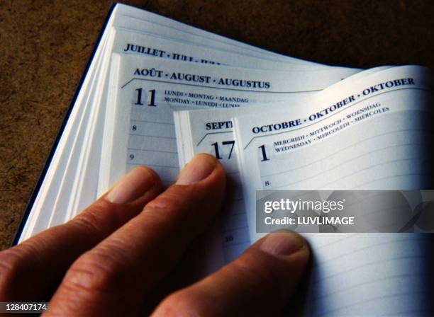 hand holding open diary - mes fotografías e imágenes de stock
